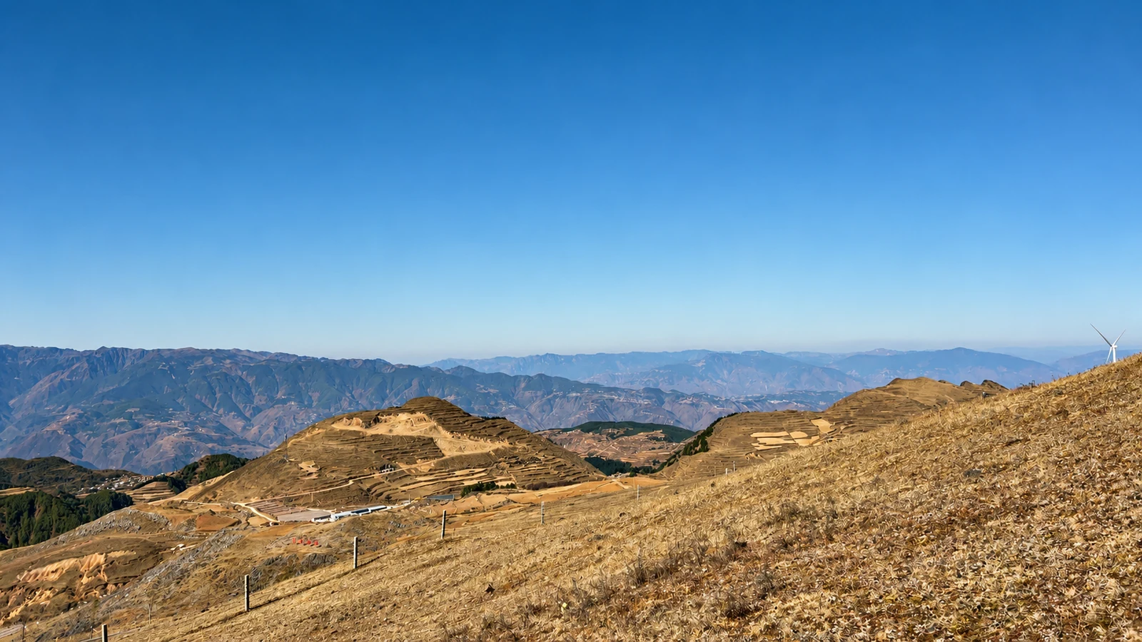 Terraced hills and distant mountain ridges under a clear Yunnan sky